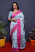 Pink linen silk saree with modern digital prints and decorative jacquard border, paired with a sky blue blouse.