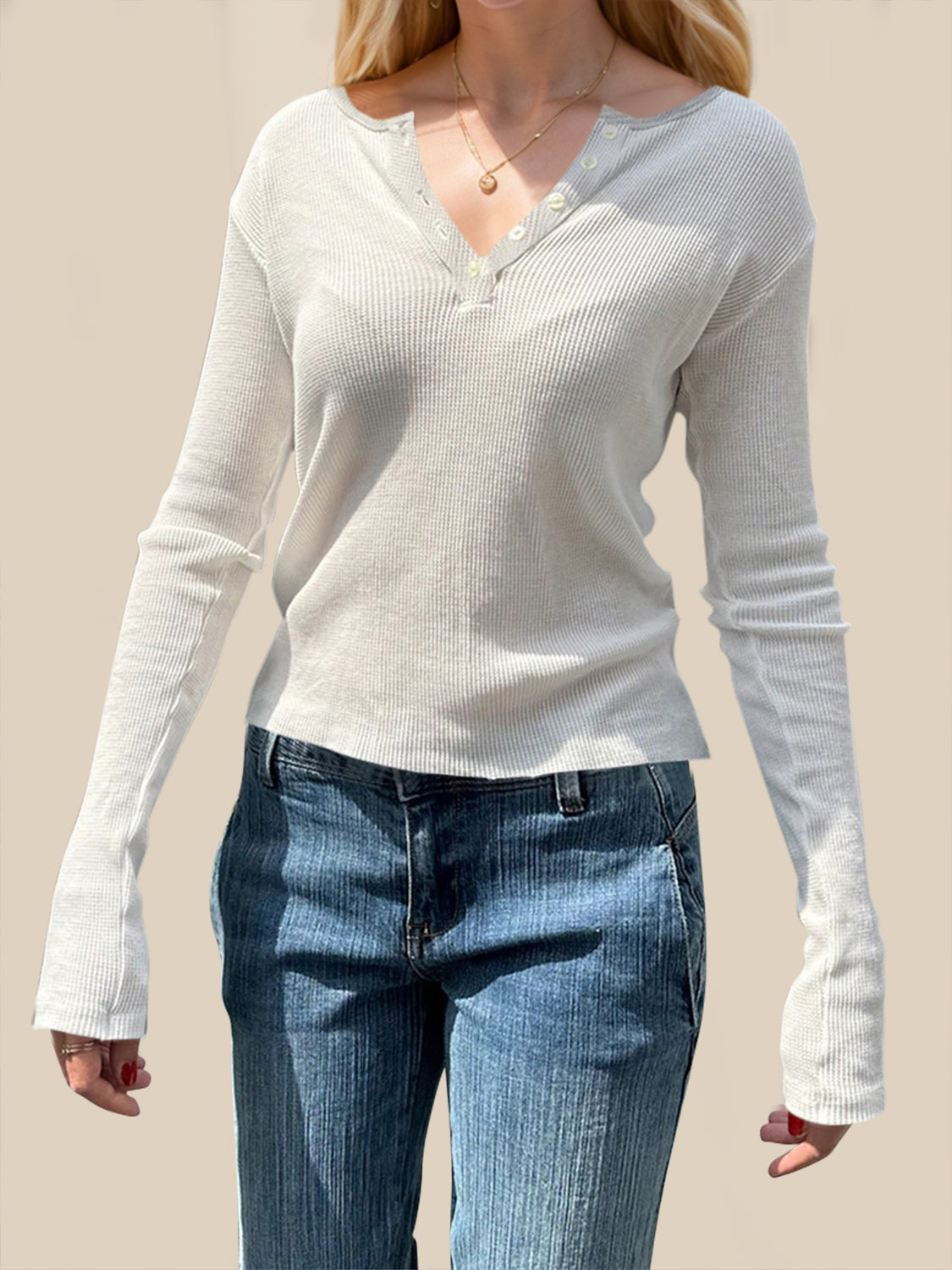 A woman wearing a white long-sleeve waffle knit shirt with a button-up henley neckline, viewed from the front and back.