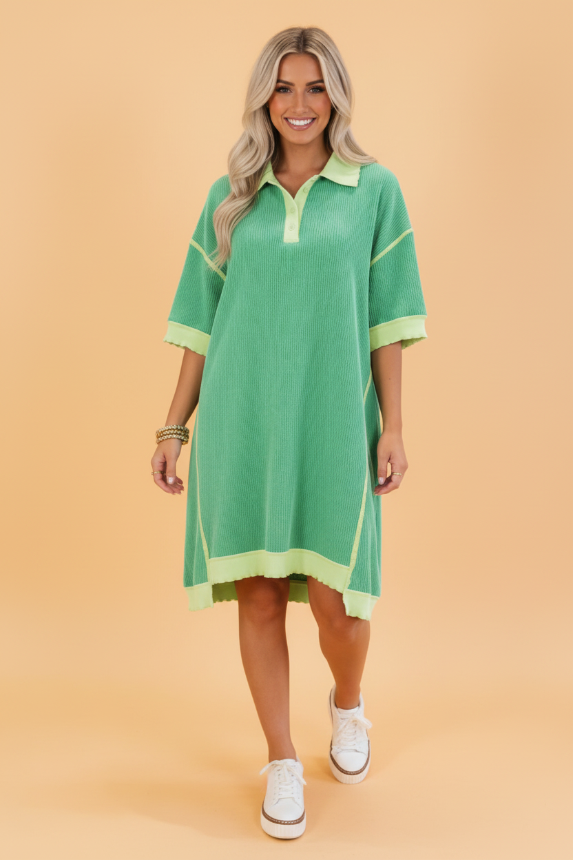 A woman modeling a green colorblock corded knit oversized polo t-shirt dress against a tan background.