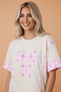 Woman wearing a romantic floral daisy bow patchwork cotton short sleeve t-shirt in beige and pink.