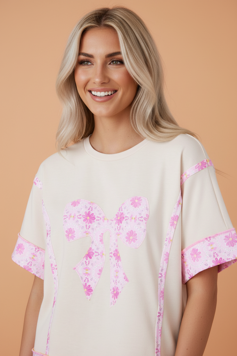 Woman wearing a romantic floral daisy bow patchwork cotton short sleeve t-shirt in beige and pink.