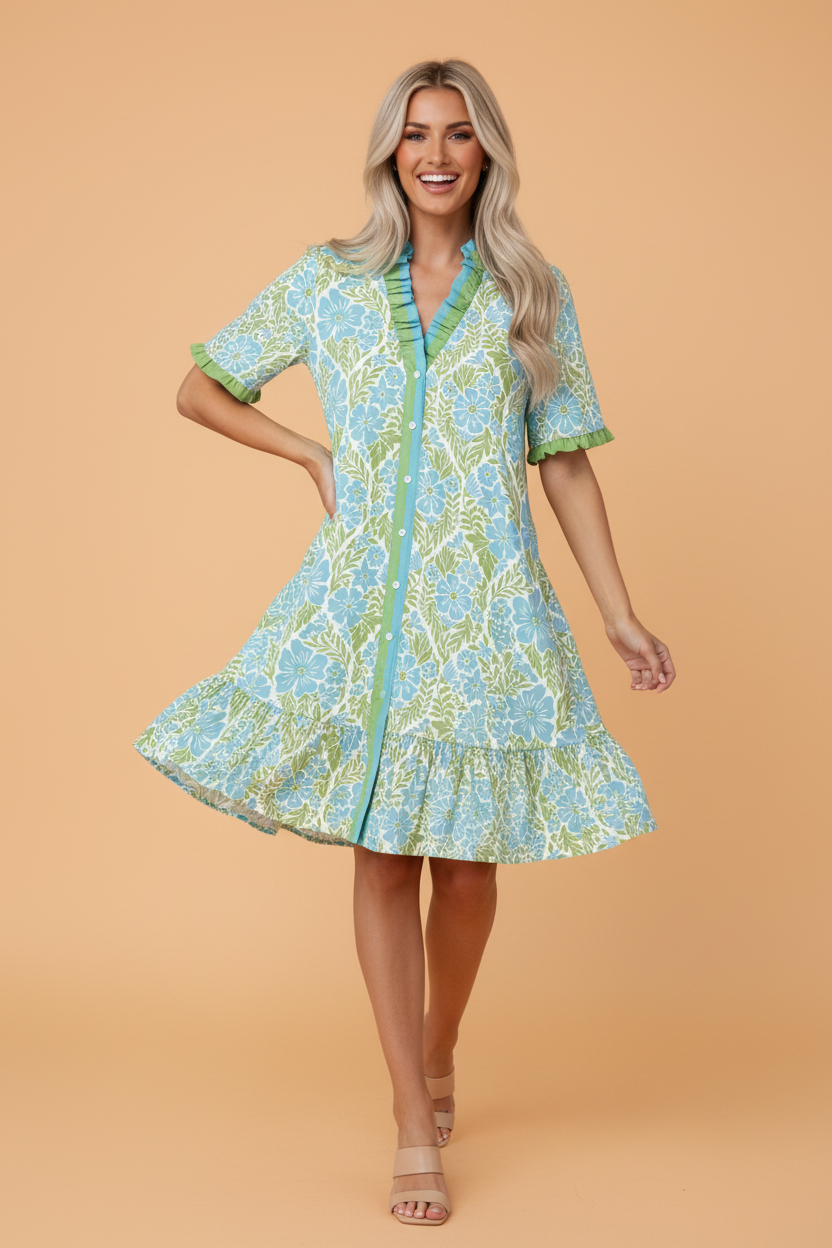 Woman wearing a floral light blue and green V-neck button front dress with ruffle sleeve details