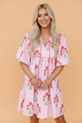 A romantic pink and white striped cotton mini dress with a red floral pattern, tie neckline, and short puff sleeves.