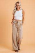 Woman wearing beige high-waist wide-leg pants with mineral wash finish and elastic waistband