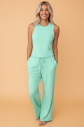 Woman wearing a mint green knit two-piece lounge set with a sleeveless crew-neck tank and wide-leg drawstring pants.