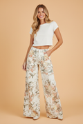 High waist wide leg denim jeans with vintage floral print in peach, mustard, and sage on an off-white background.
