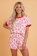 Leopard print loungewear set with contrast trim top and loose shorts in cream, pink, and red