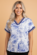 Close up of a white and blue floral blouse with striped trim on the v-neck and cuffs