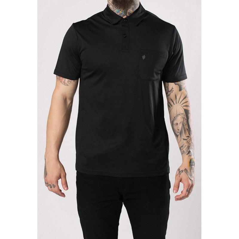 Professional barber wearing a moisture-wicking black barber polo with mesh side panels