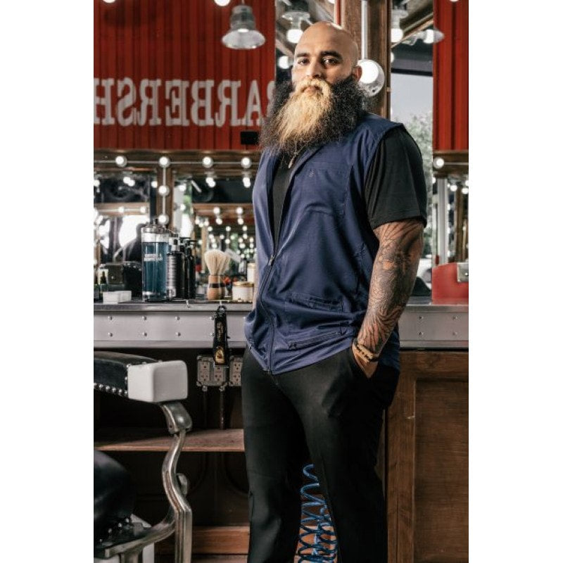 Professional male barber wearing a black sleeveless, water-resistant Barber Strong vest with a 2-way zipper.