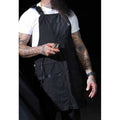Professional barber apron with padded neck strap and multiple tool pockets in a shop setting.