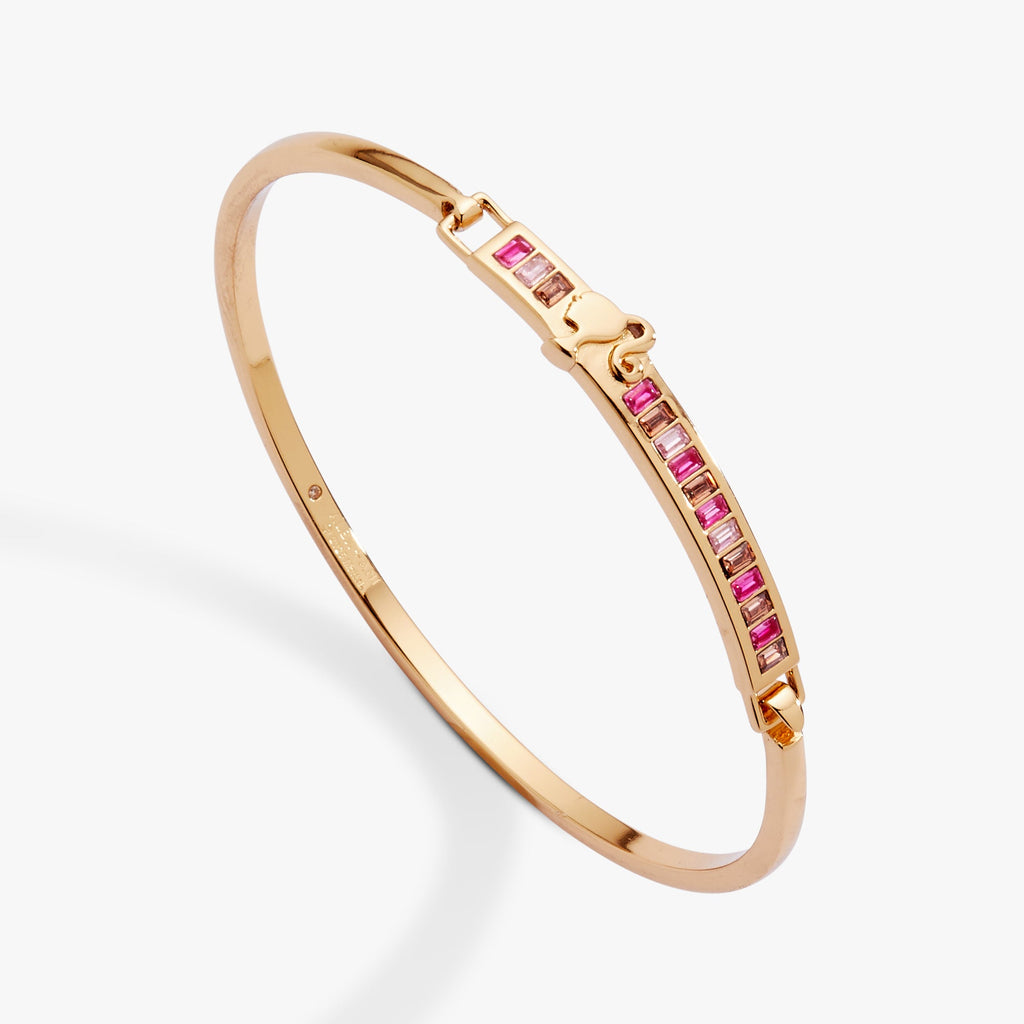 Barbie tension bangle featuring tonal pink stones, Barbie head motif, and engraved message
