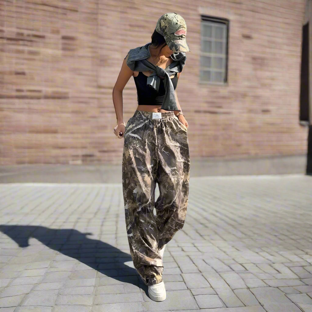 Model wearing baggy Y2K camouflage cargo pants with a black crop top and baseball cap