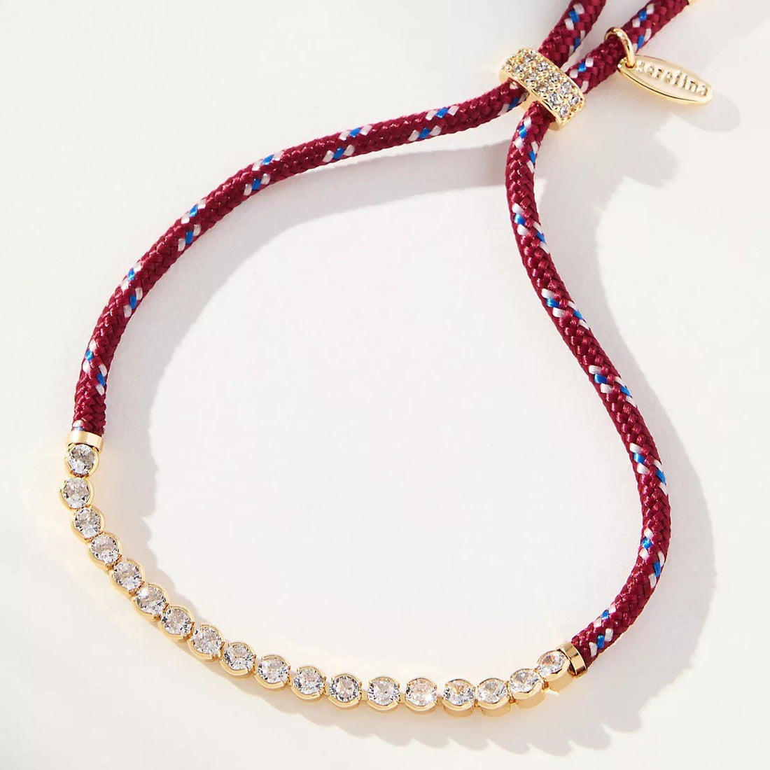 Off-white and brown striped woven pendant necklace with diamond-encrusted chain on a white background.