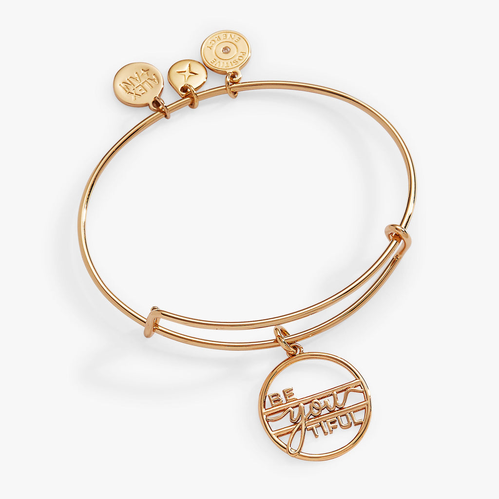 Minimalist gold Be-You-Tiful charm bangle on a neutral background