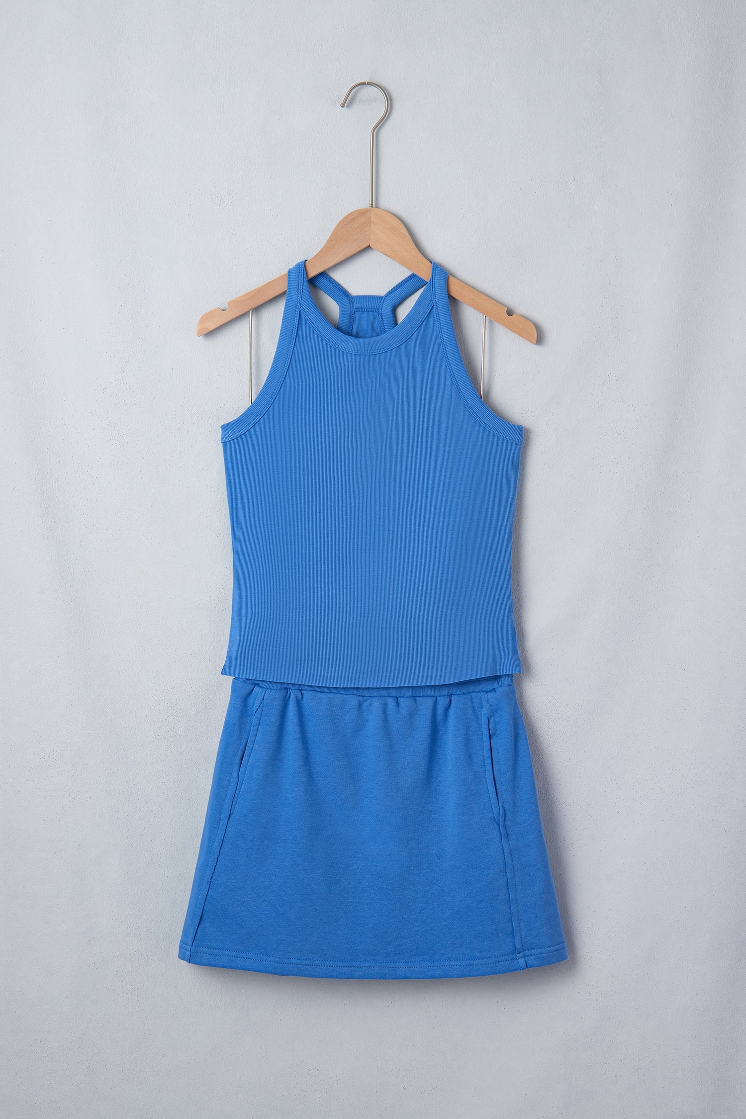 Model wearing a sky blue matching set with a slim tank top and elastic waist mini skort