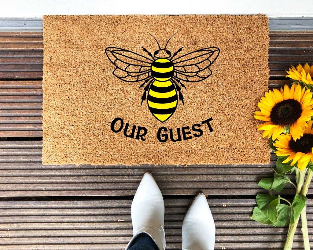 Bee Our Guest themed doormat in brown, black, and yellow