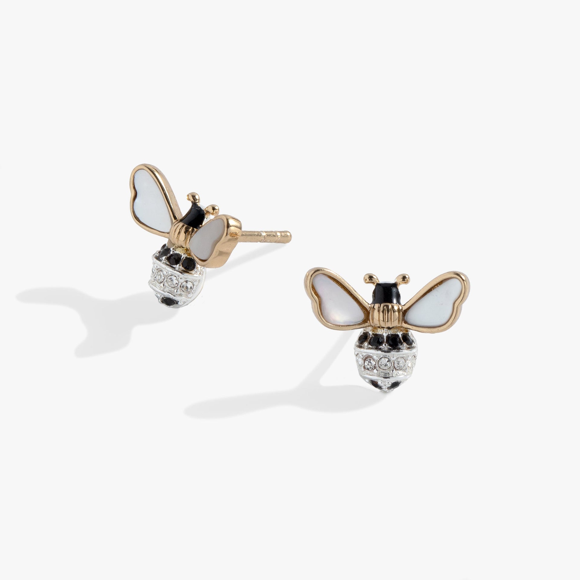 Close up of gold and silver bee stud earrings with iridescent mother-of-pearl wings and crystal details