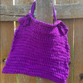 A flat lay of a beginner-friendly knitted T-Shirt yarn bag kit in assorted colors.