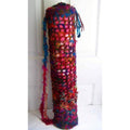 Hand-crafted bohemian crochet yoga mat bag featuring vibrant magenta, purple, blue, and gold sari silk yarn with tie closure.