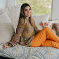 A flat lay view of a bohemian multicolored knit sweater DIY kit with vibrant yarn and a pattern download.