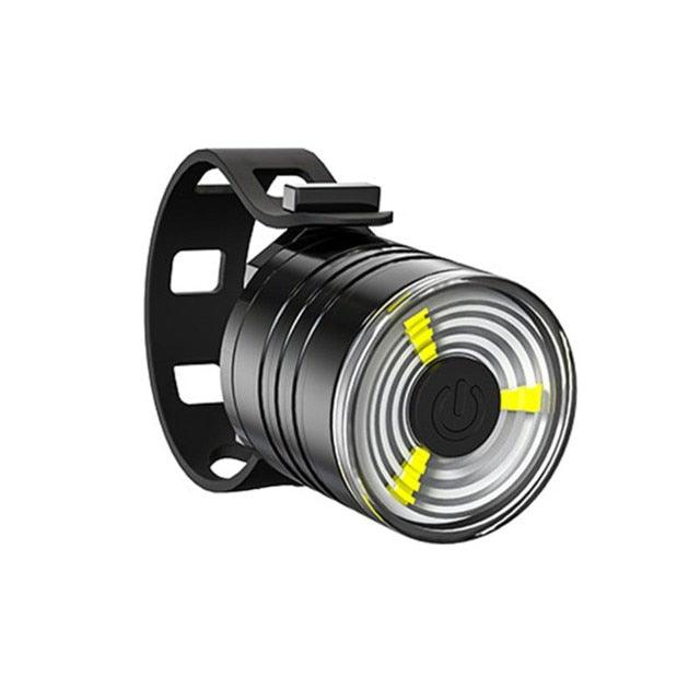 Modern aluminum alloy LED bicycle tail light in black with red and white indicators mounted on a bicycle