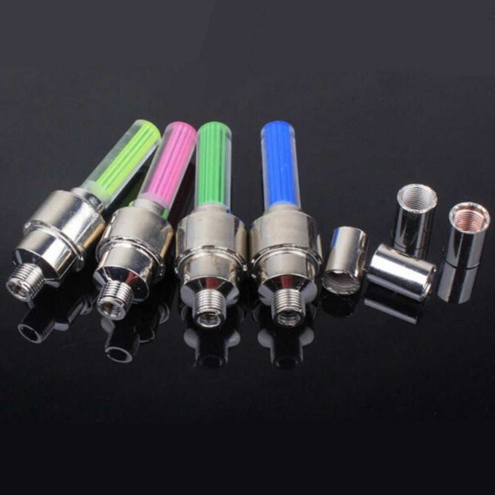 LED tire valve cap lights illuminating bicycle wheels at night