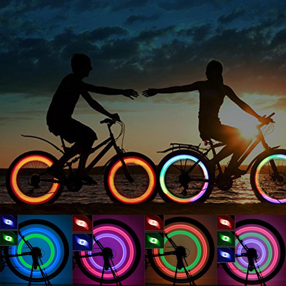 Neon blue and green LED bike spoke lights glowing on bicycle wheels during a night ride