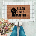 Black Lives Matter text printed on a durable natural coir doormat for front porch entryways.