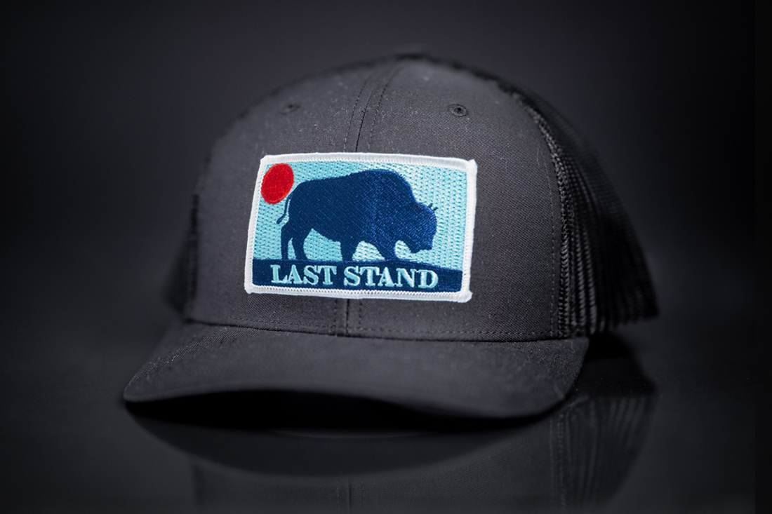 Last Stand Bison Sunset curved bill trucker hat available in black, blue, and red.