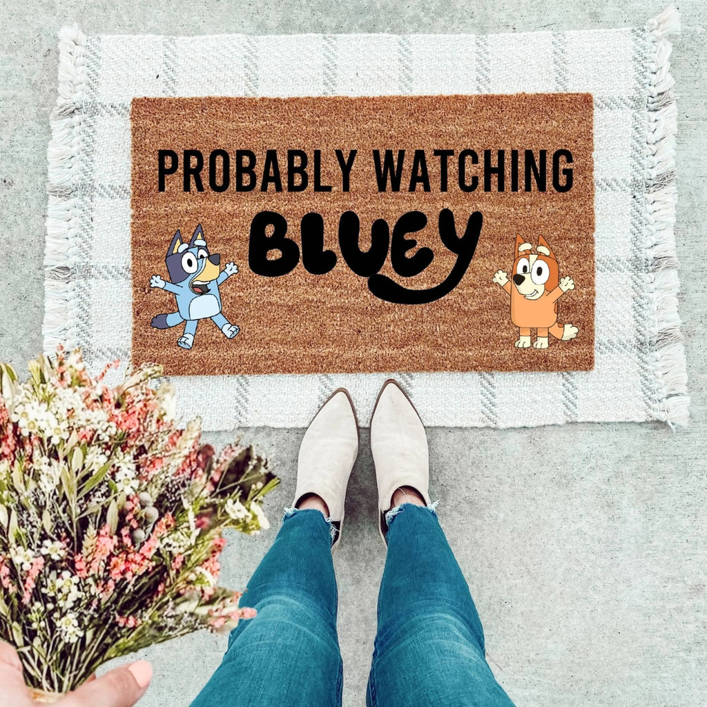 Blue dog and Bingo character inspired welcome mat on a wooden front porch