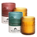A pair of Pine & Spice Aromática scented candles in festive holiday packaging