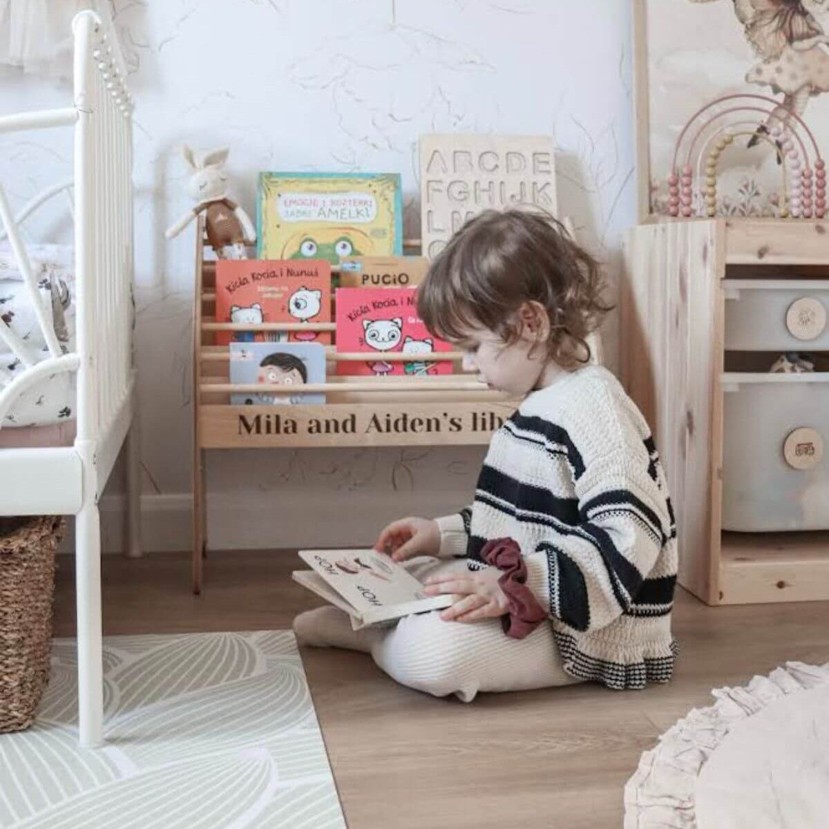 Minimalist wooden Montessori bookshelf in a kids' playroom with books displayed front-facing.