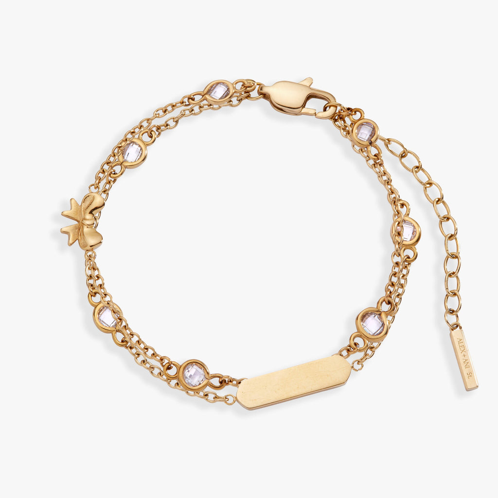 Double strand bracelet with bow symbols and crystal accents in polished metal