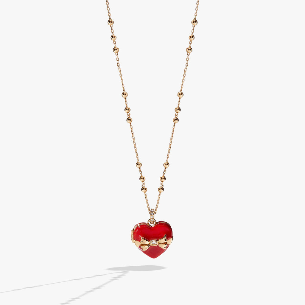 Heart-shaped locket necklace with a crystal bow, opening to reveal chocolate-colored crystals.