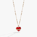 Heart-shaped locket necklace with a crystal bow, opening to reveal chocolate-colored crystals.