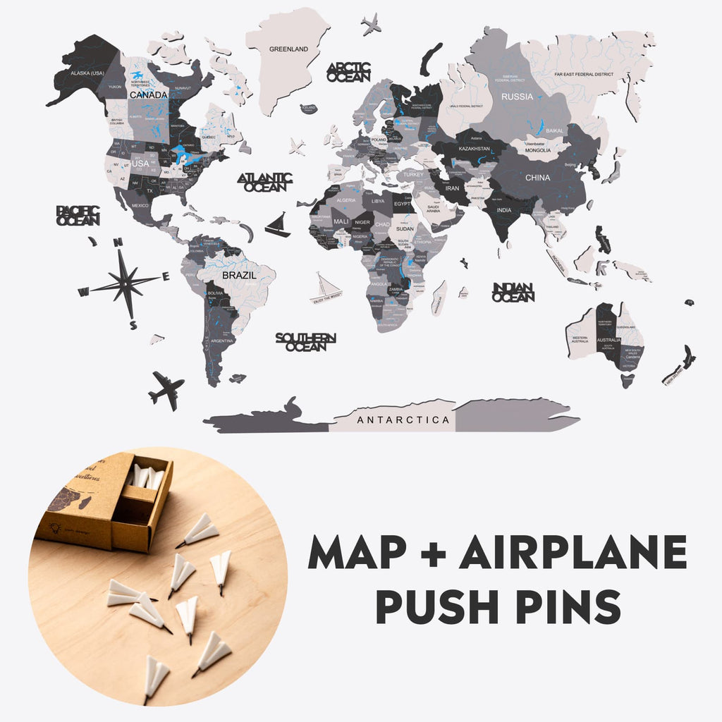 Minimalist wooden world map wall decor with airplane push pins in grey, white, and black