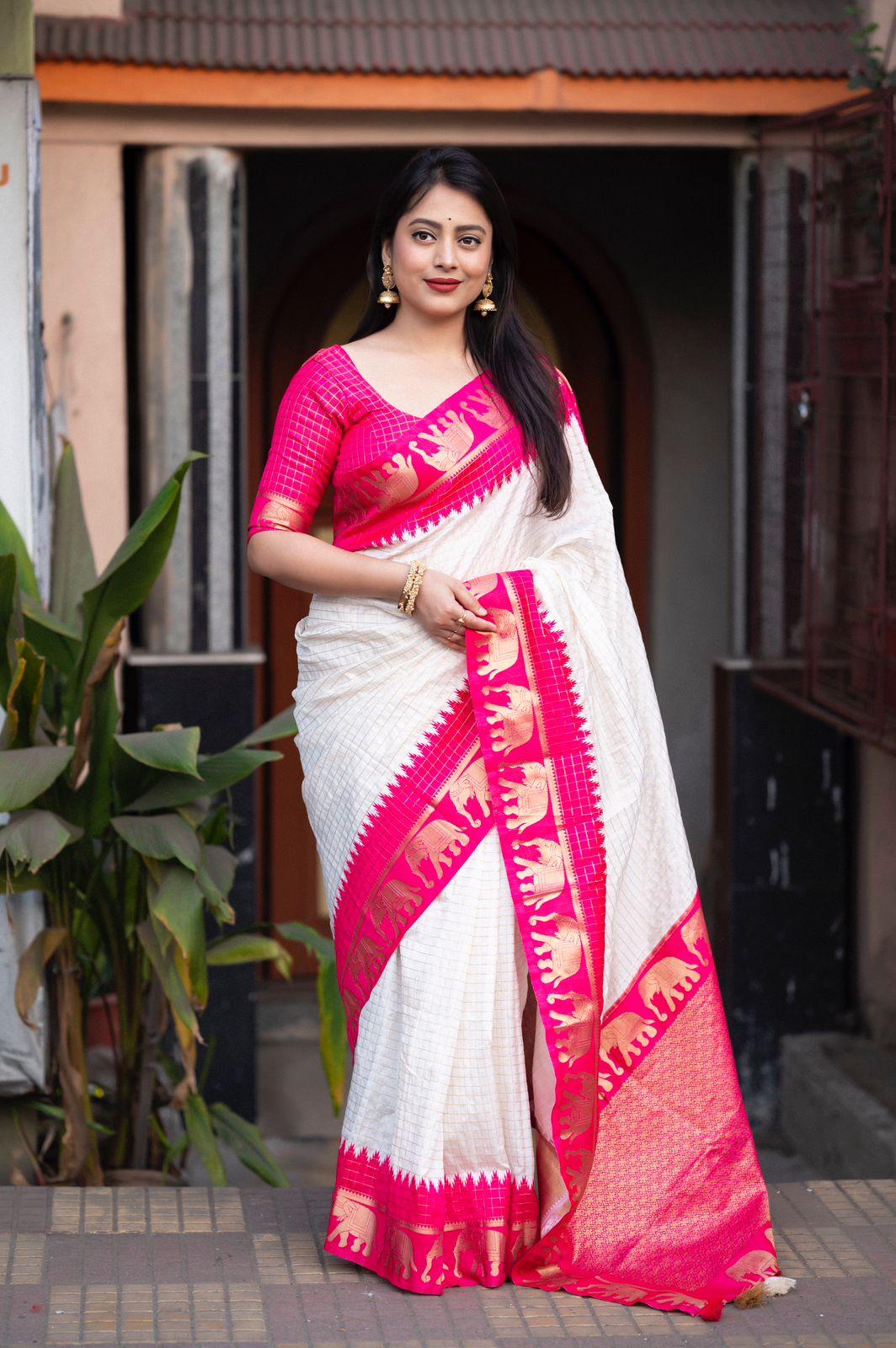 Rani pink silk saree featuring zari woven chex and elephant motif border