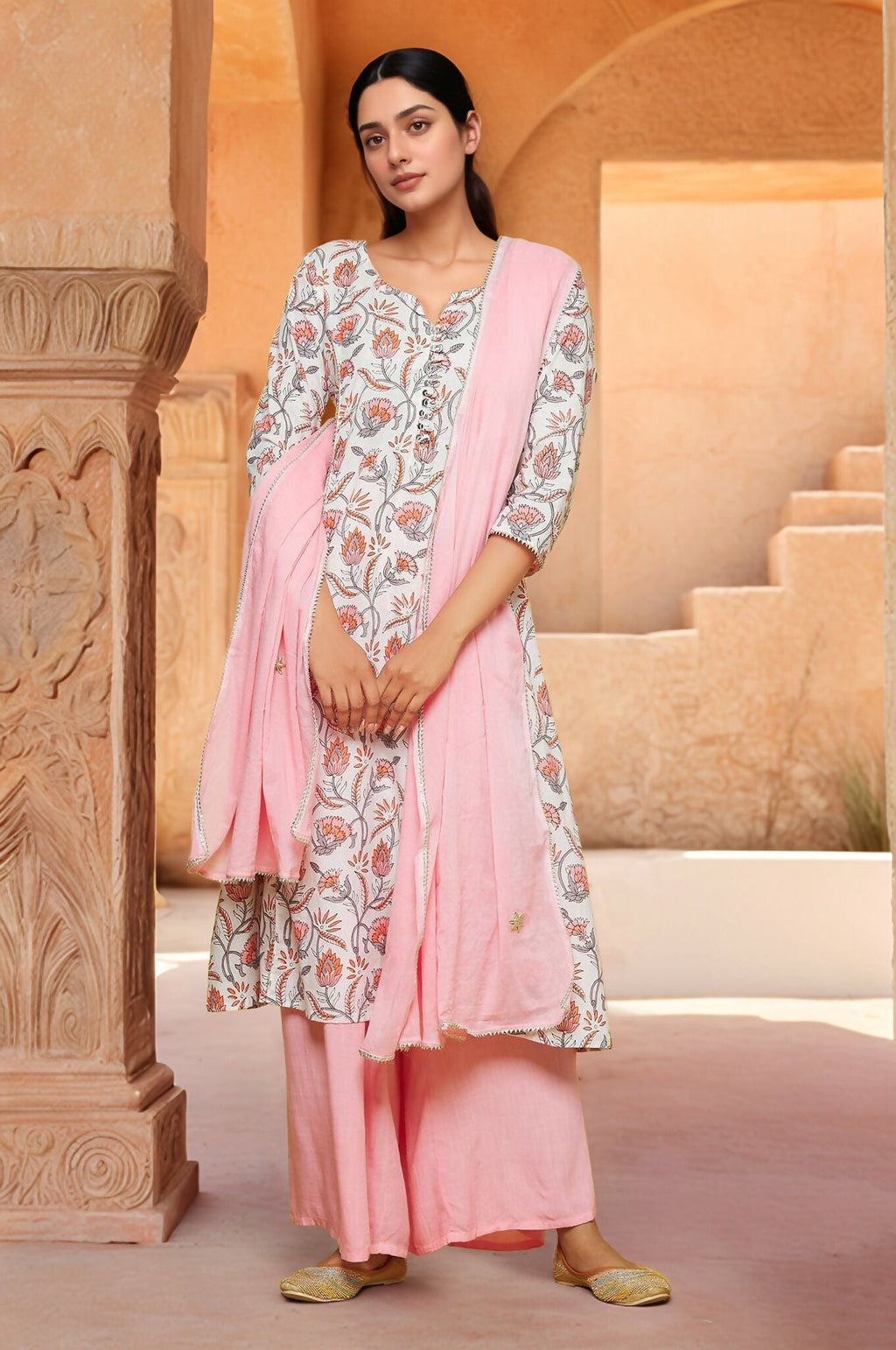 Woman wearing a white cotton A-line kurti with floral print and a contrast palazzo set