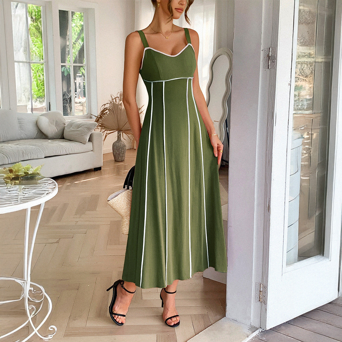 A woman wearing a modern minimalist high waist sling dress in solid color available in apricot, green, brick red, and navy blue.