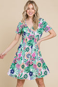 Floral print V-neck dress with ruched waist and short sleeves in green, white, and pink.
