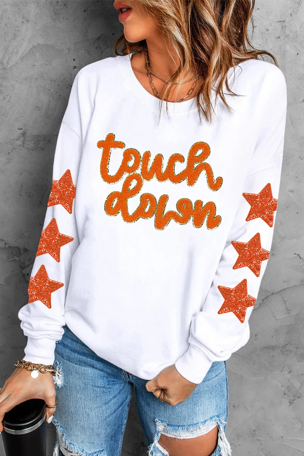Streetwear-style sweatshirt with letter and star graphics in white and orange.