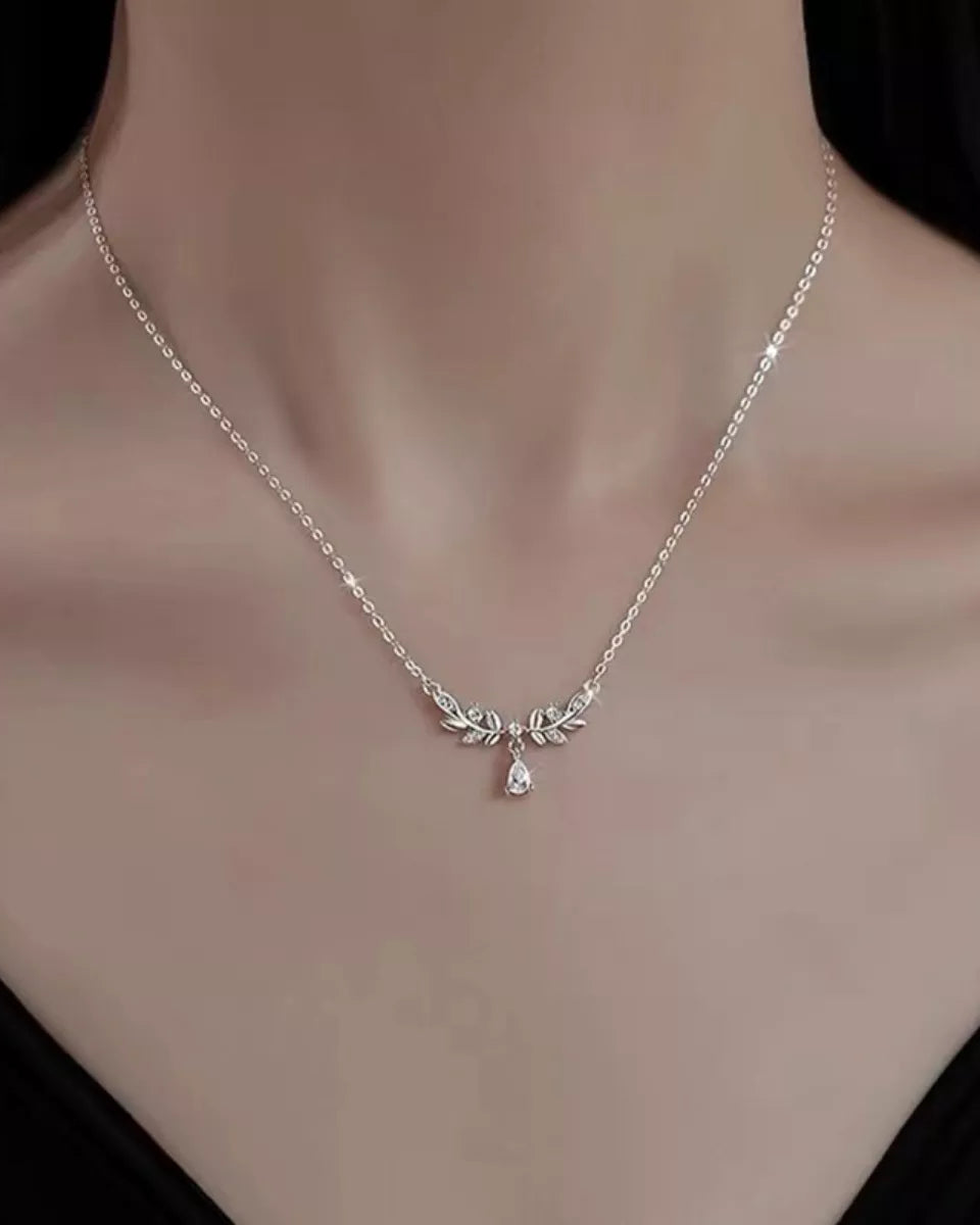 Silver necklace with leaf and teardrop pendant on a mannequin