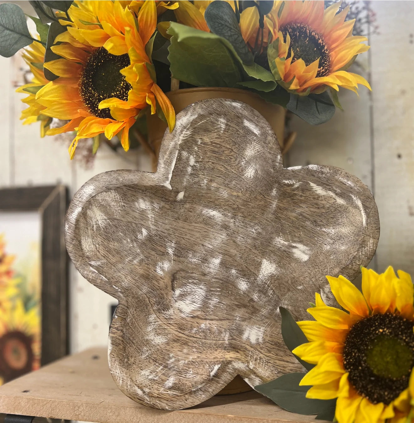 A rustic 10-inch whitewashed wooden tray shaped like a flower, styled next to sunflowers.