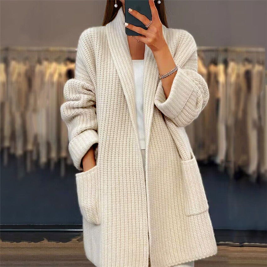Woman wearing a loose-fit Milky White lapel knitted cardigan with front pockets.