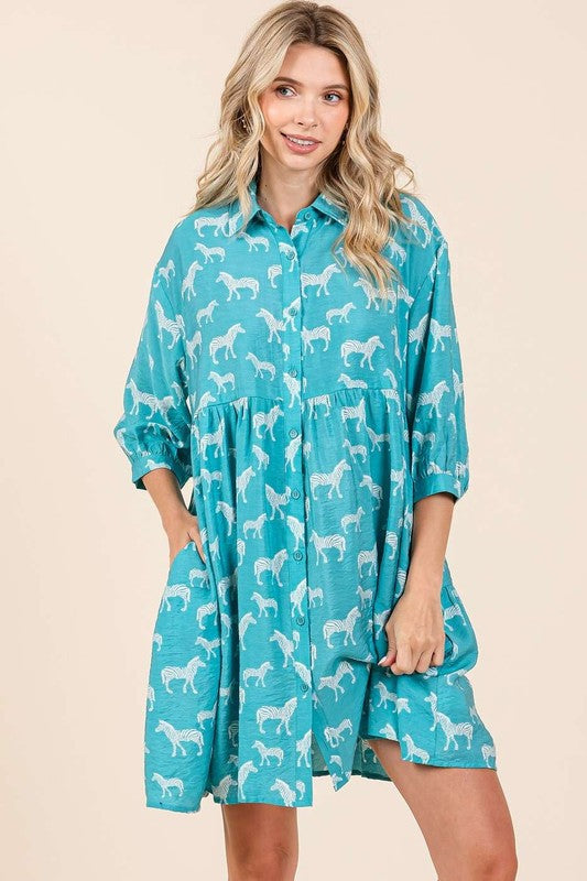 Model wearing a zebra print button-down shirt mini dress with tiered detailing.