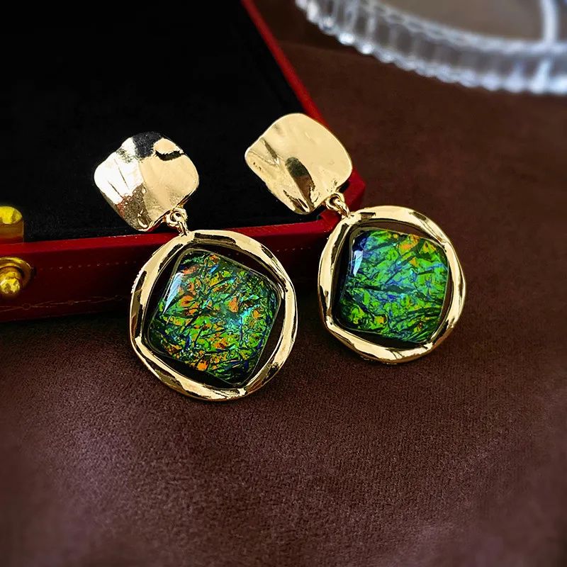 Vintage gold dangle earrings featuring rhombus shapes and green resin inlay