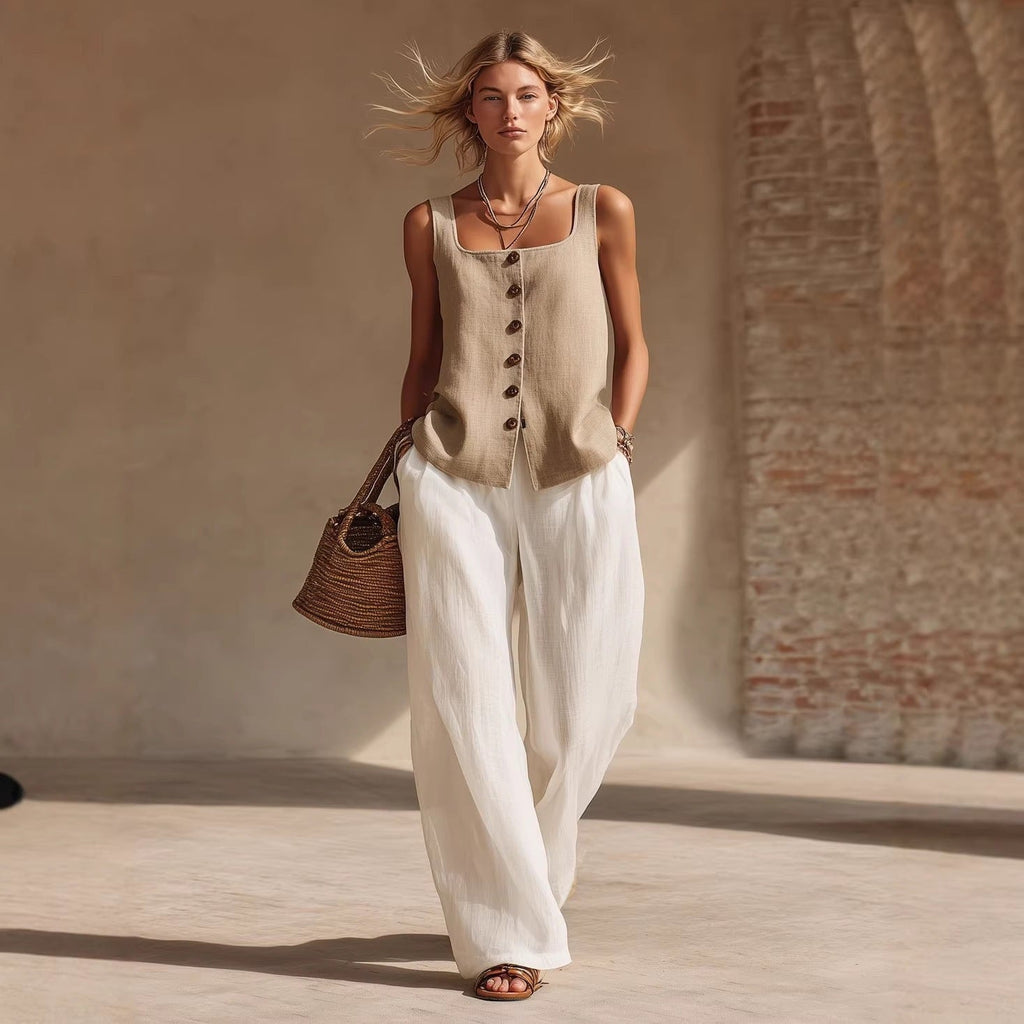 Model wearing a beige sleeveless button-down top and white wide-leg trousers as a set.