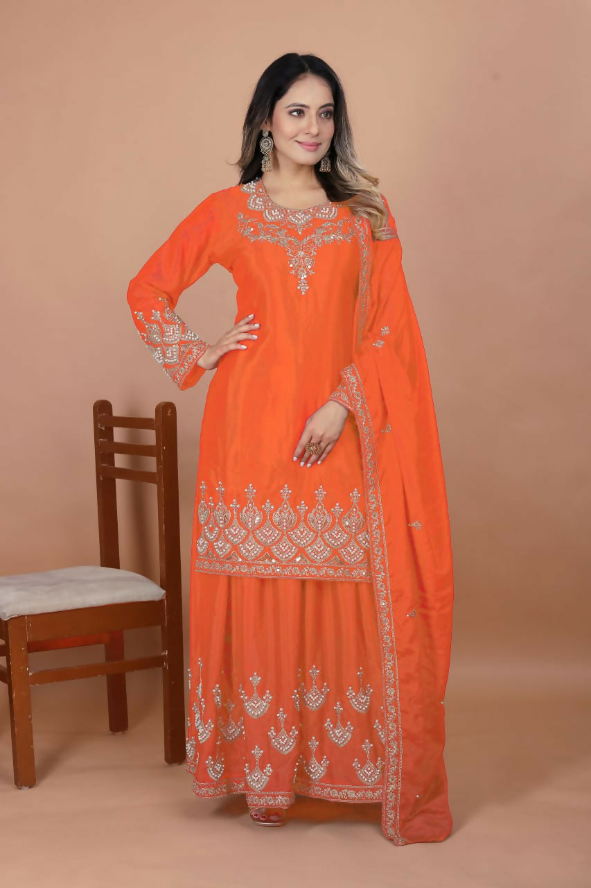 Orange silk kurti with intricate embroidery paired with matching sharara bottoms
