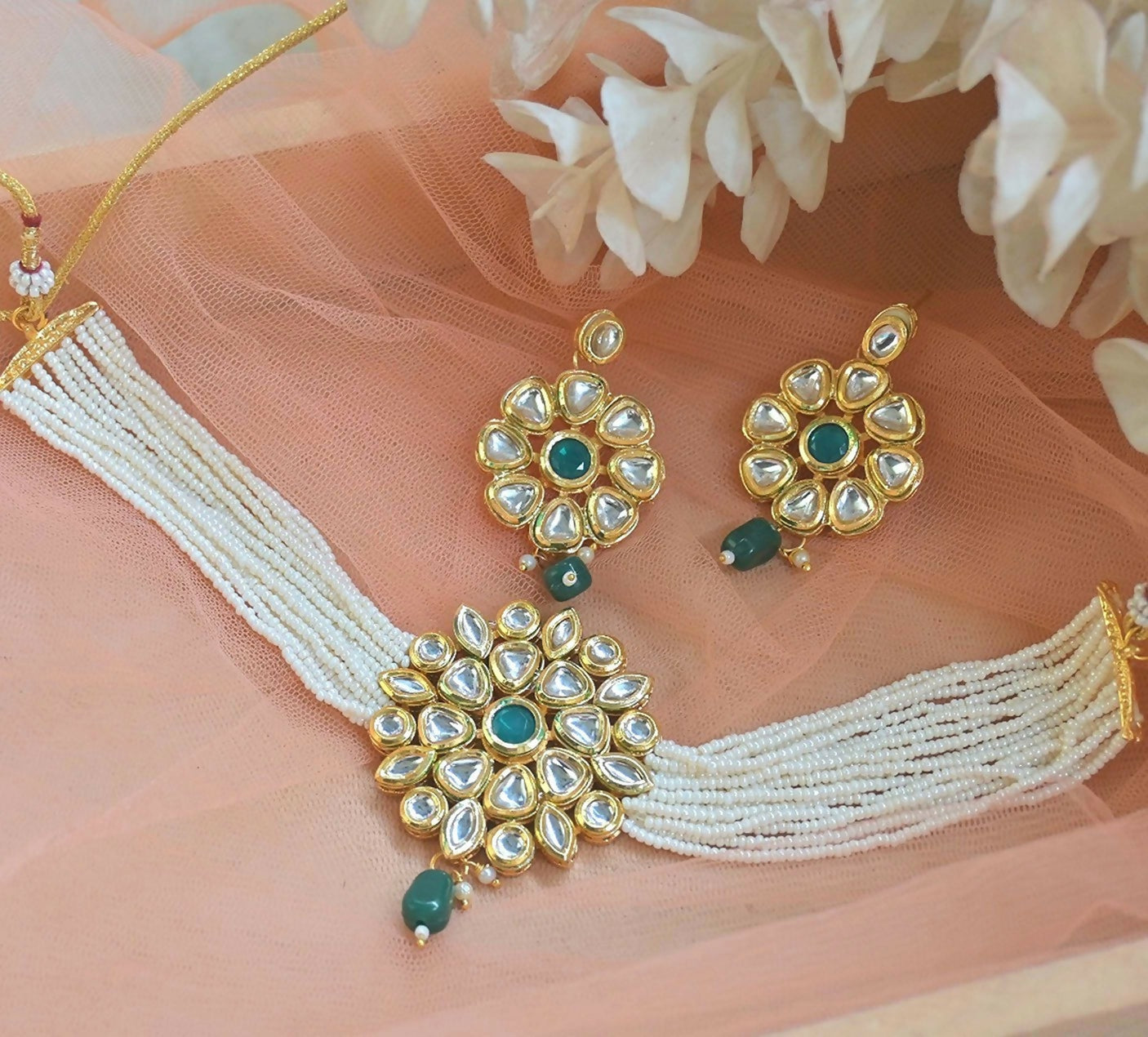 Traditional copper-based Kundan choker necklace with emerald green and white floral motifs